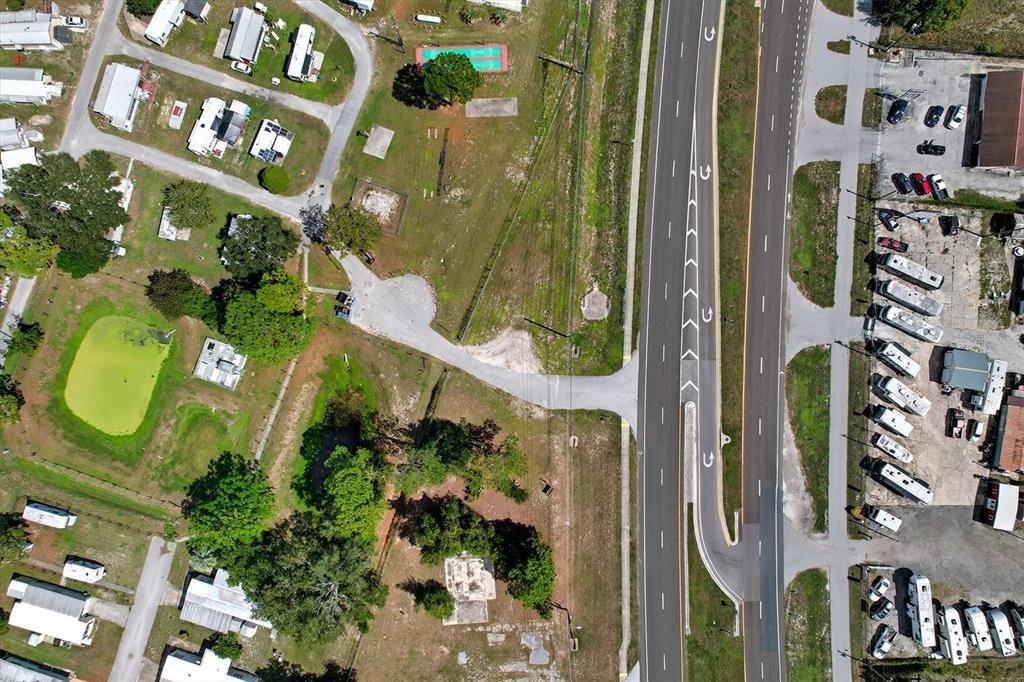 An aerial view shows a divided highway adjacent to a residential area with mobile homes — 15541 CORTEZ BOULEVARD, BROOKSVILLE, FL