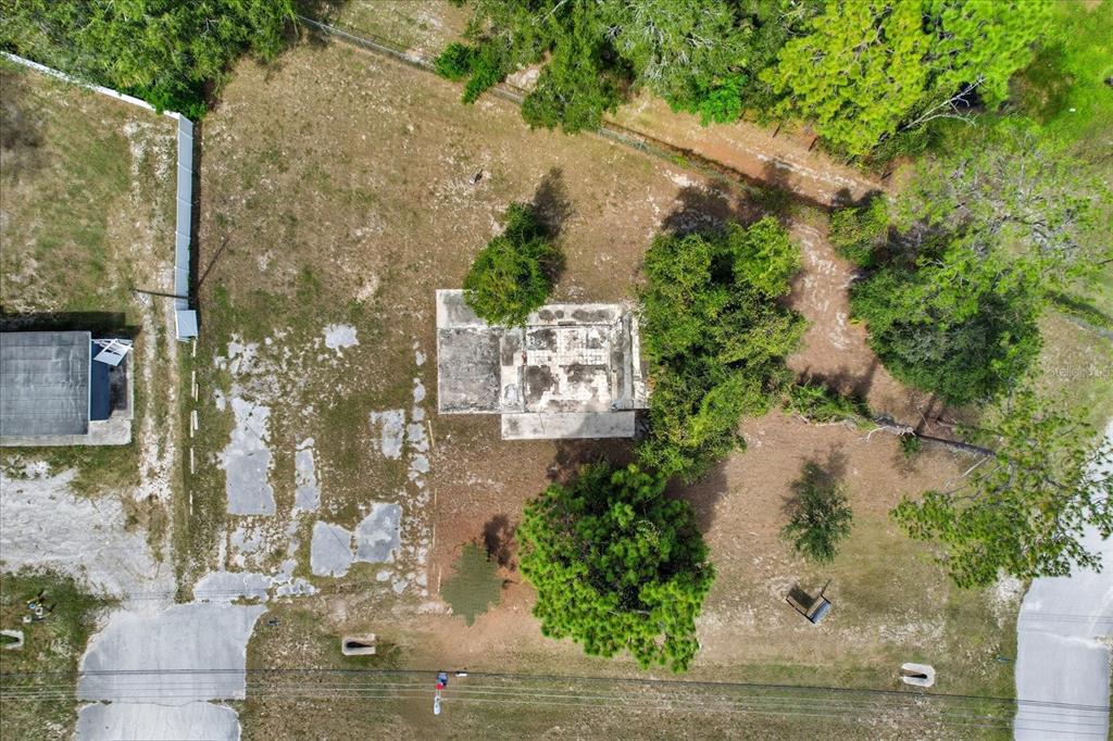 An aerial view shows a vacant lot with a concrete building foundation and scattered trees — 15541 CORTEZ BOULEVARD, BROOKSVILLE, FL