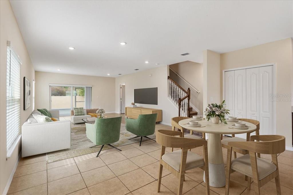 A living and dining area with tile floors, a staircase, and virtual staging furniture — 4855 CORAL CASTLE DRIVE, KISSIMMEE, FL