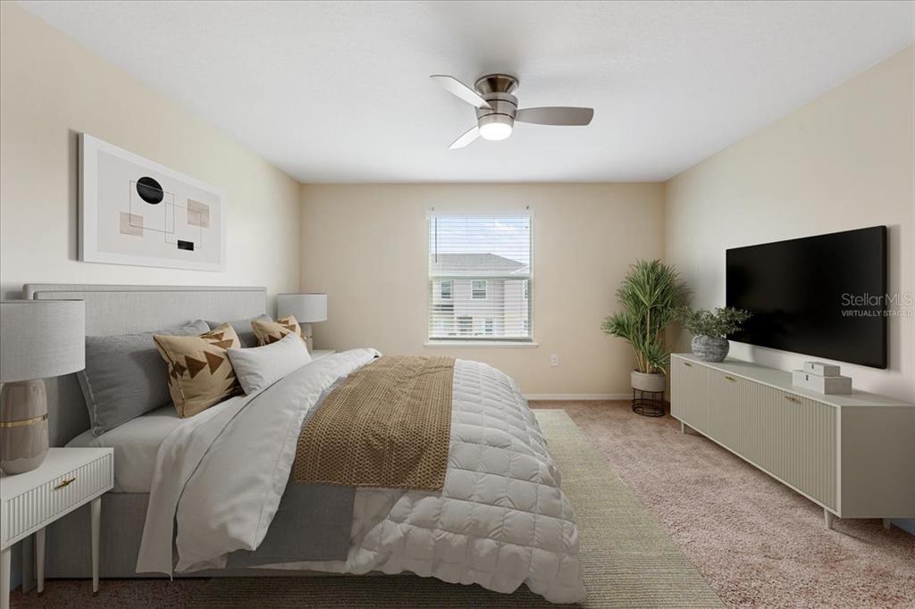 A virtually staged bedroom features a bed, a ceiling fan, and a wall-mounted television — 4855 CORAL CASTLE DRIVE, KISSIMMEE, FL