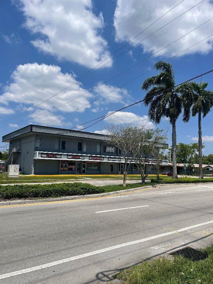 A two-story commercial strip mall with palm trees stands along a paved road — 1075 Sunset Strip, Sunrise FL 33313, SUNRISE, FL