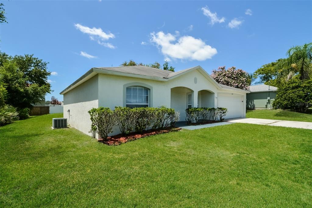 A single-story house with a white stucco exterior, a two-car garage, and a front lawn — 2783 S SLATER DRIVE, DELTONA, FL