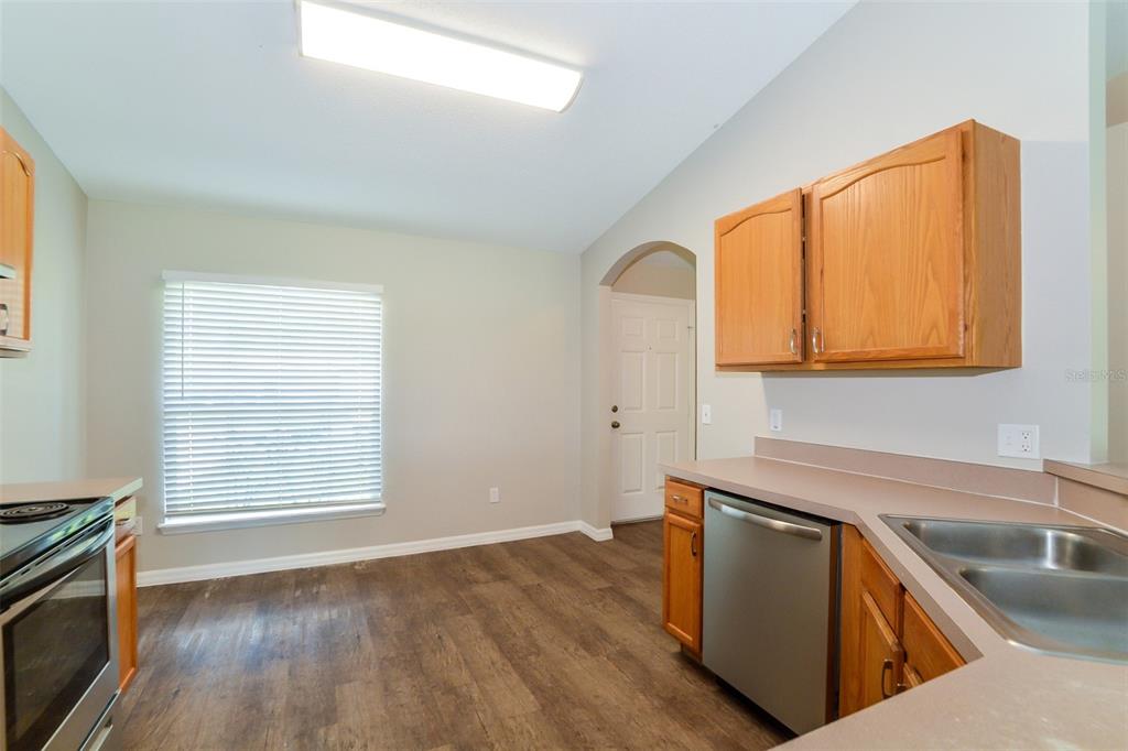 A kitchen with wood cabinets, stainless steel appliances, and wood-look flooring — 2783 S SLATER DRIVE, DELTONA, FL