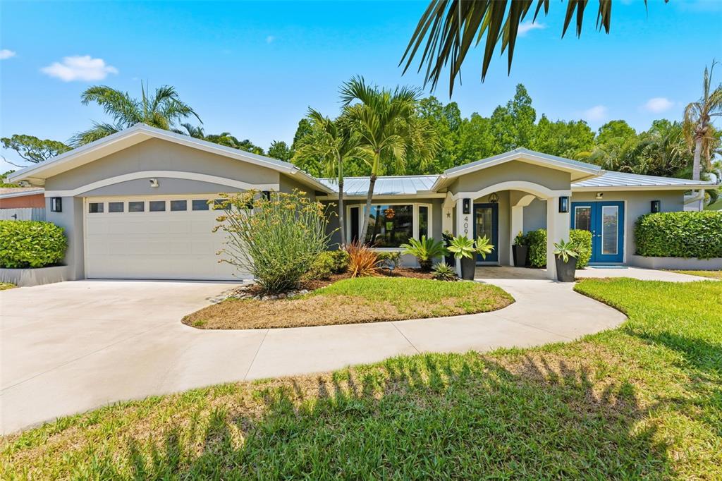 A blue front door with glass inserts sits on a tiled porch with landscaping — 4096 38TH STREET S, ST PETERSBURG, FL