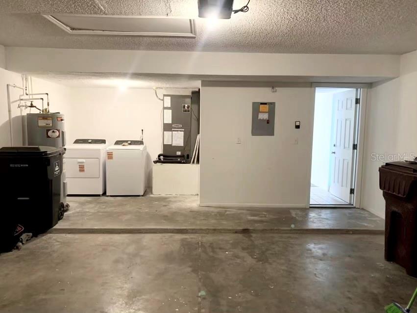 A garage with a concrete floor, laundry appliances, a water heater, and an HVAC unit — 5120 MYSTIC POINT COURT, ORLANDO, FL