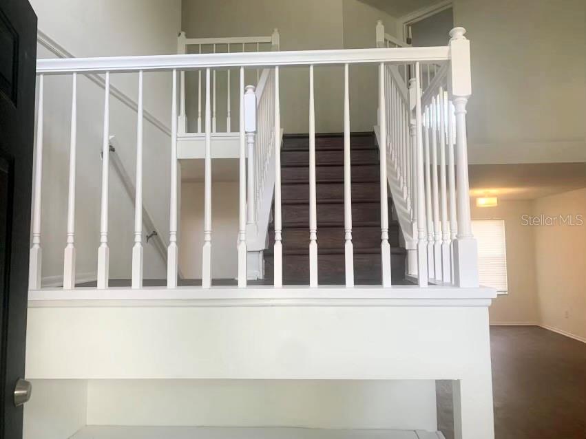 A staircase with white railings and dark wood treads leads to an upper landing — 5120 MYSTIC POINT COURT, ORLANDO, FL