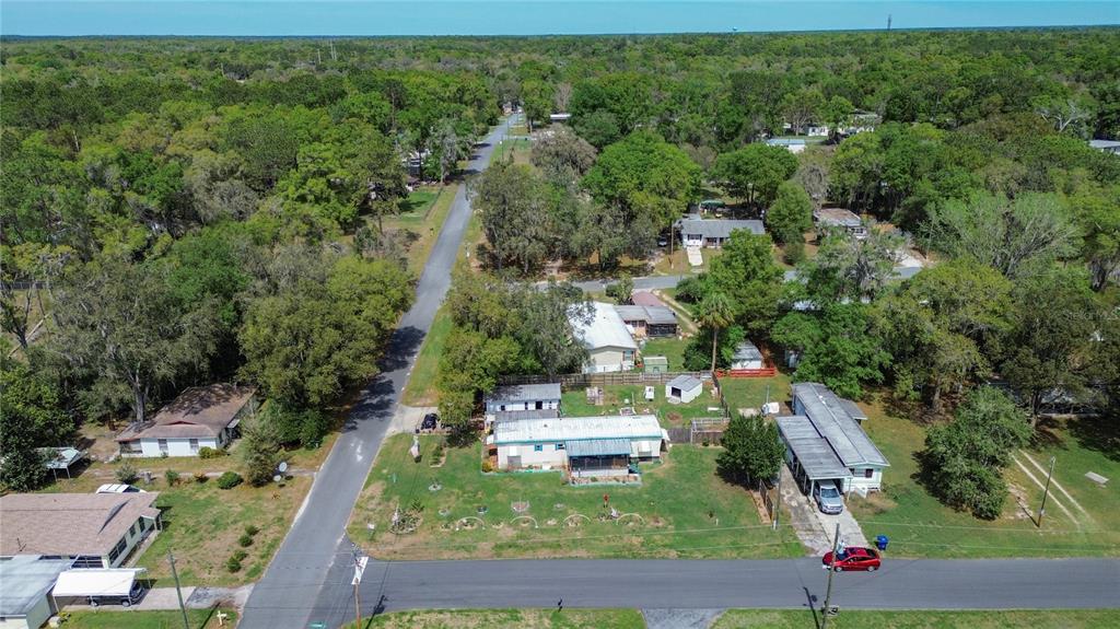 An aerial view shows a residential street with several mobile homes surrounded by dense trees — 7951 E PARTRIDGE LANE, FLORAL CITY, FL