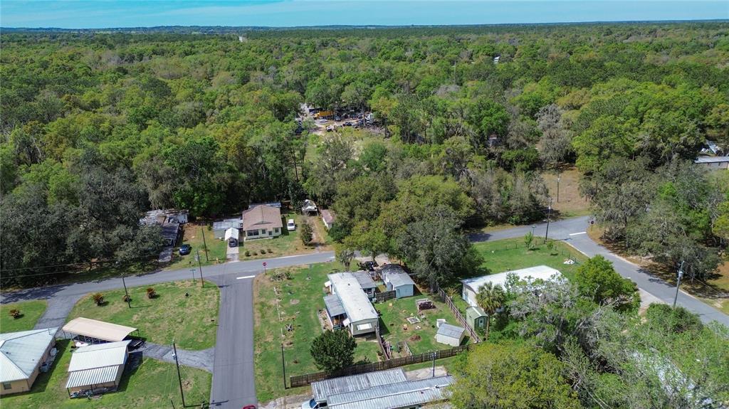 An aerial view shows several houses and mobile homes surrounded by trees and paved roads — 7951 E PARTRIDGE LANE, FLORAL CITY, FL