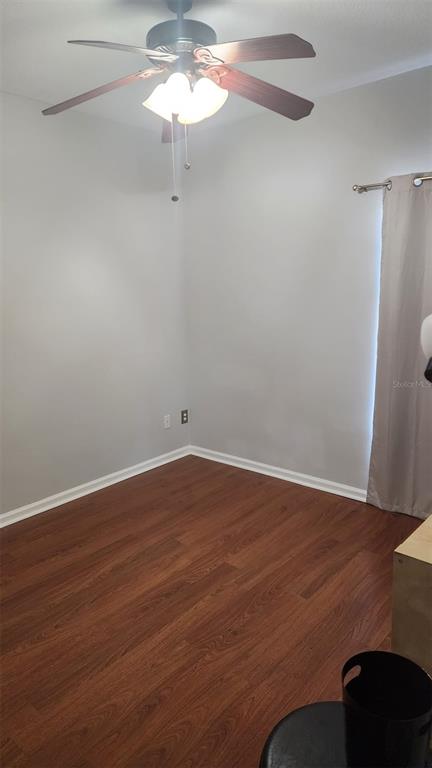 A room with wood-look flooring, light gray walls, a ceiling fan, and a window with curtains — 13561 HAWK LAKE DRIVE, ORLANDO, FL