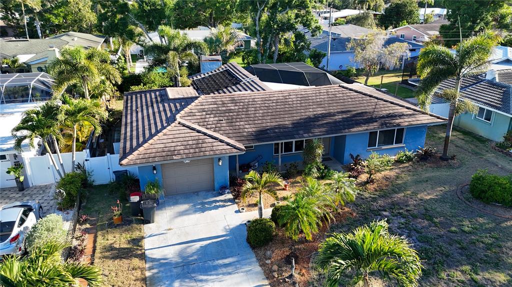 An aerial view of a blue single-story house with a brown tile roof and driveway — 33 SOUTHWIND DRIVE, BELLEAIR BLUFFS, FL