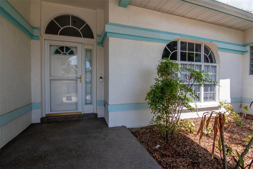 The exterior entrance features a white front door with a sidelight and arched windows — 5715 TANASI COURT, LAKELAND, FL