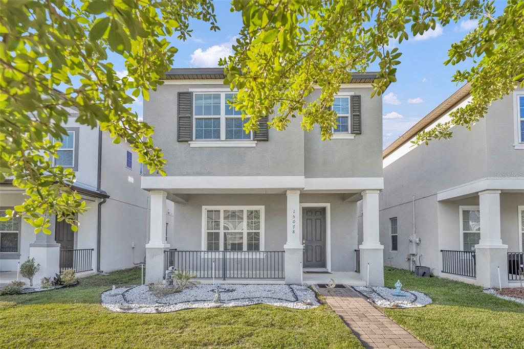 A two-story gray house with a front porch, black shutters, and a paved walkway — 15078 WILLOW ARBOR CIRCLE, ORLANDO, FL