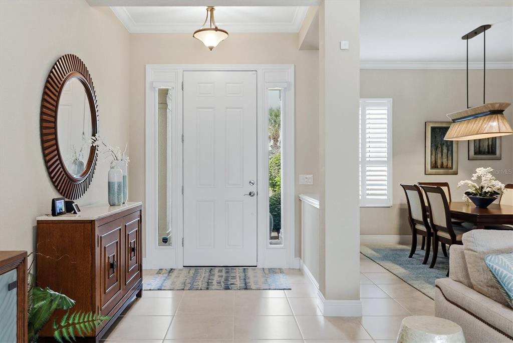 A bright entryway features a white front door with sidelights, tile flooring, and a mirror — 295 MARSH CREEK ROAD, VENICE, FL