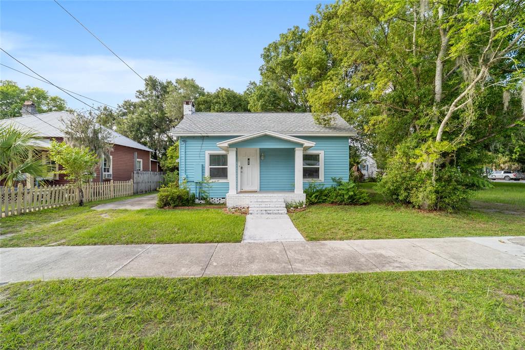 A light blue, single-story house with a front porch and a concrete walkway — 20837 WALNUT STREET, DUNNELLON, FL