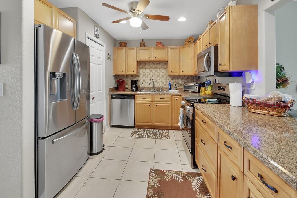 A kitchen with light wood cabinets, stainless steel appliances, and granite countertops — 50 BONITA ROAD, DEBARY, FL