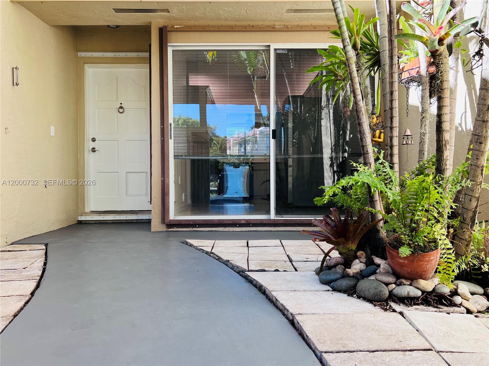 A white front door sits beside a sliding glass door on a paved patio — 4530 NW 102nd Ct, Doral FL 33178, DORAL, FL
