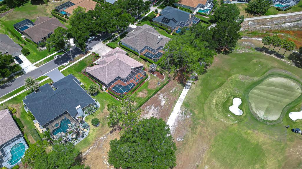 An aerial view shows several suburban houses with swimming pools bordering a golf course — 3810 TURKEY OAK DRIVE, VALRICO, FL