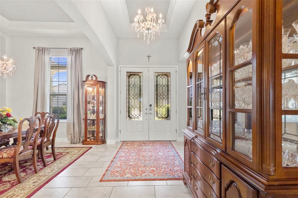 A kitchen island with a sink and dishwasher overlooks a living area and outdoor pool — 13340 FAWN LILY DRIVE, RIVERVIEW, FL