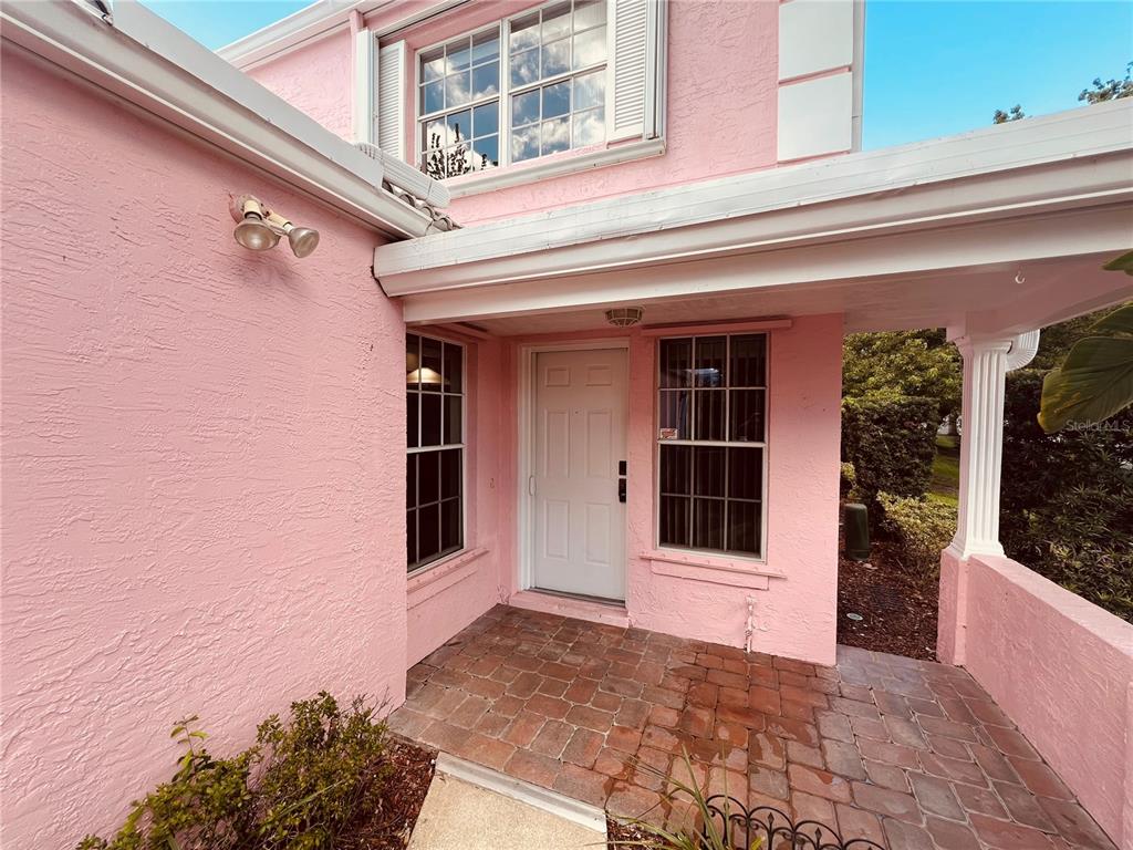 A pink two-story house with a white roof sits behind a Cypress Creek entrance sign — 4931 WALDEN CIRCLE UNIT 55, ORLANDO, FL