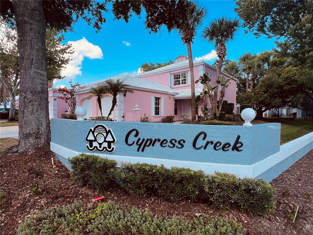 A two-story pink house with a white tile roof and a paved walkway — 4931 WALDEN CIRCLE UNIT 55, ORLANDO, FL