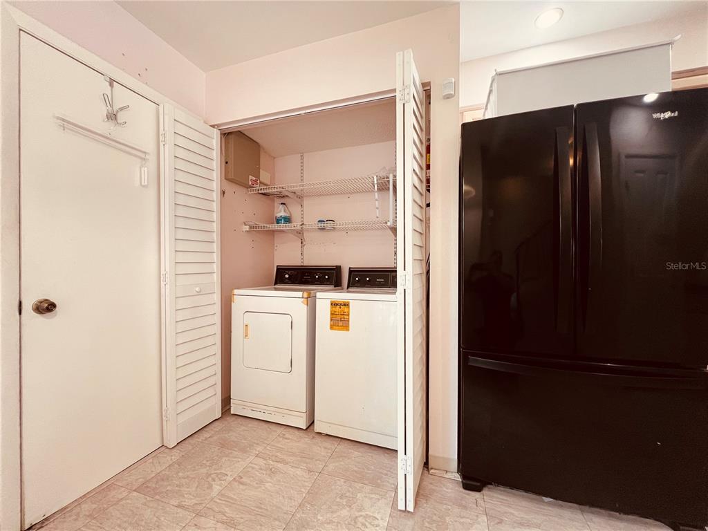 A pink-painted exterior porch features a white door, two windows, and a brick floor — 4931 WALDEN CIRCLE UNIT 55, ORLANDO, FL