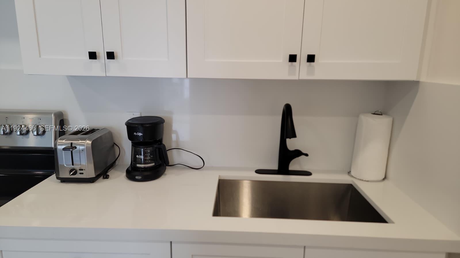 A kitchen counter features a stainless steel sink, black faucet, toaster, and coffee maker — 2820 SW 13th # 4, Miami FL 33145, MIAMI, FL