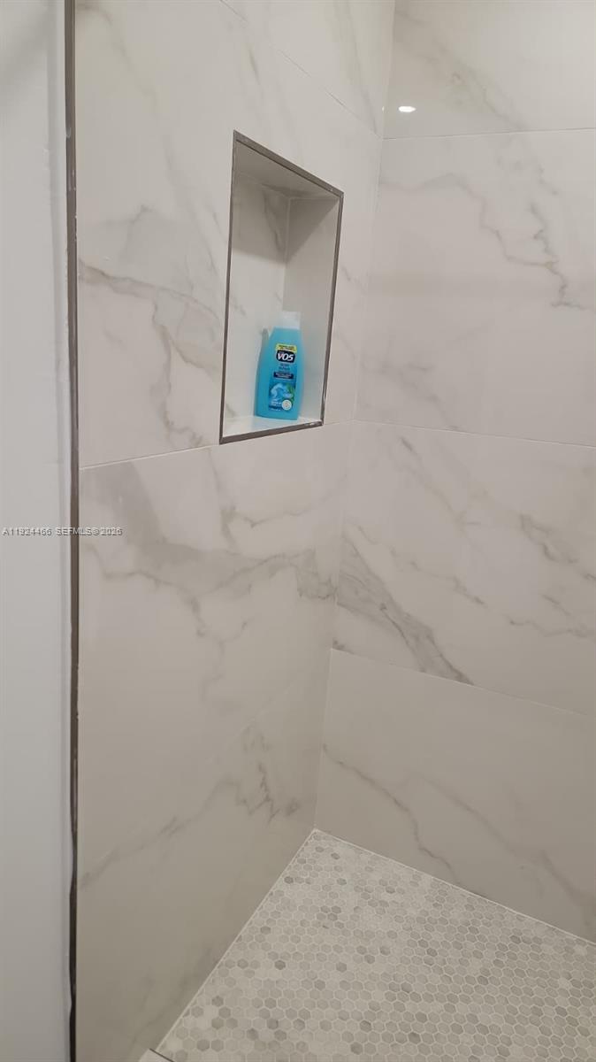 A tiled shower features a built-in wall niche and a small hexagonal tile floor — 2820 SW 13th # 4, Miami FL 33145, MIAMI, FL