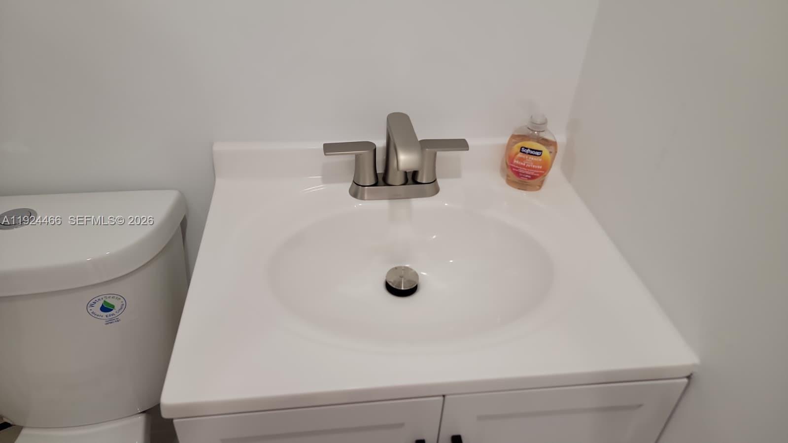A white bathroom vanity with a stainless steel faucet sits next to a toilet — 2820 SW 13th # 4, Miami FL 33145, MIAMI, FL