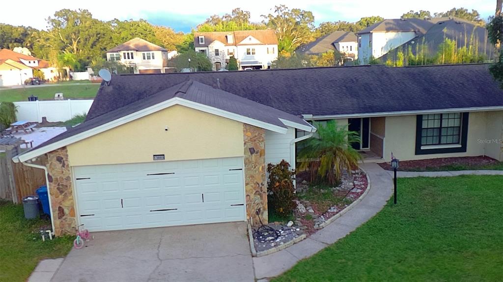 A single-story house with a white garage door, stone accents, and a concrete driveway — 13603 WESTSHIRE DRIVE, TAMPA, FL