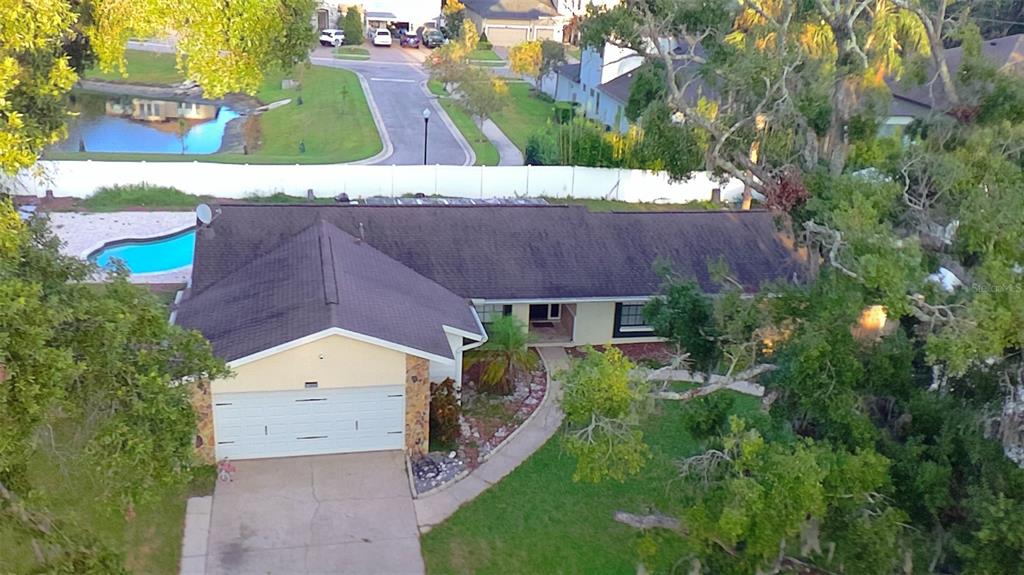 A single-story house with a two-car garage, stone accents, and a large oak tree — 13603 WESTSHIRE DRIVE, TAMPA, FL
