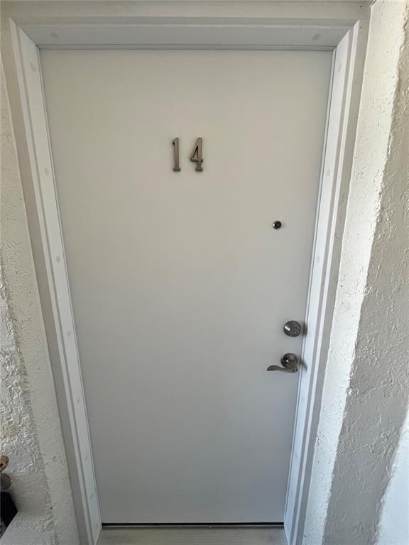 A white front door labeled with the number 14 is set within a textured wall — 2727 75TH STREET W UNIT 7A14, BRADENTON, FL