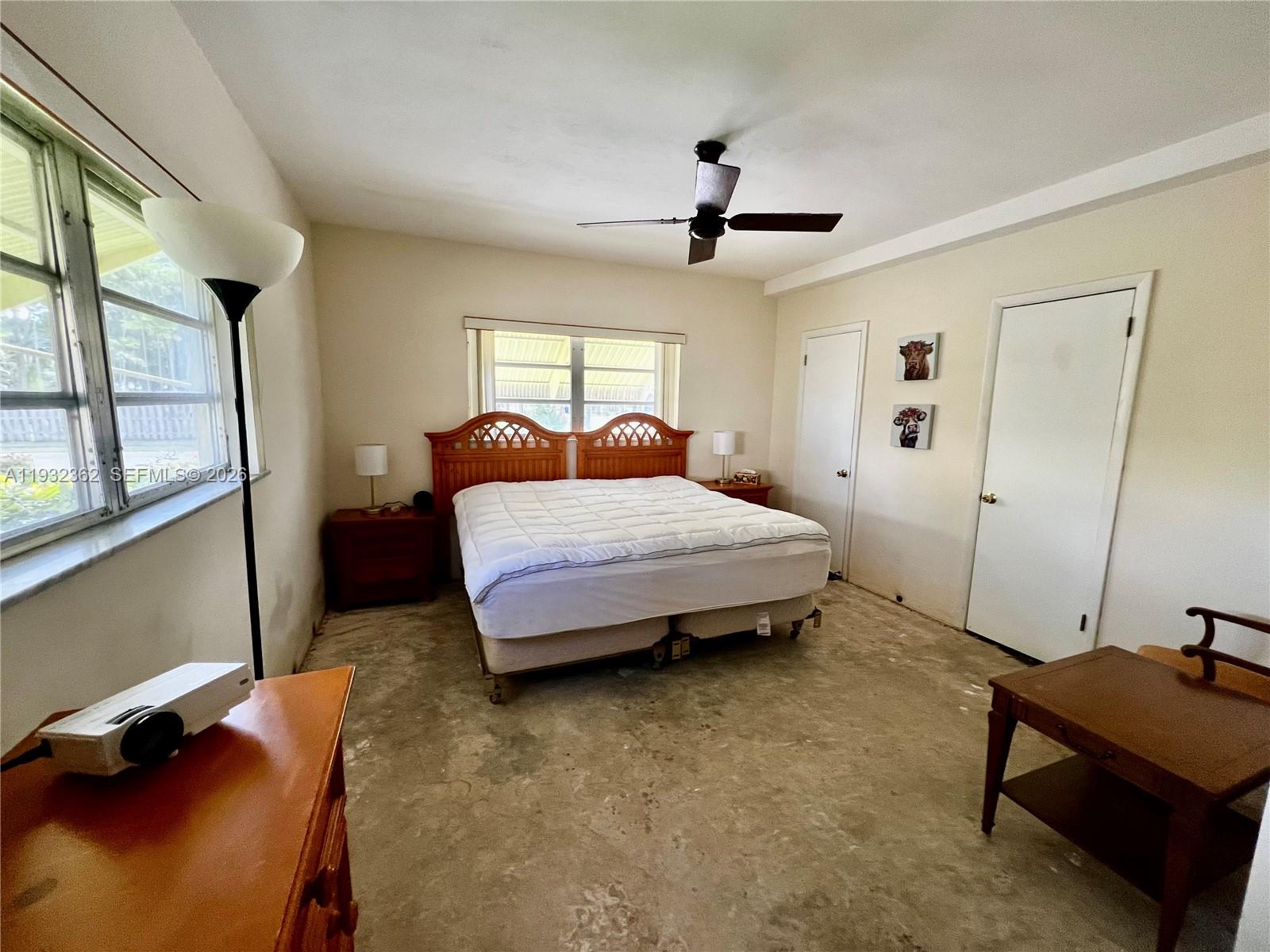 A bedroom features a bed, wooden furniture, and an unfinished concrete floor — 1501 Arthur St # 5, Hollywood FL 33020, HOLLYWOOD, FL