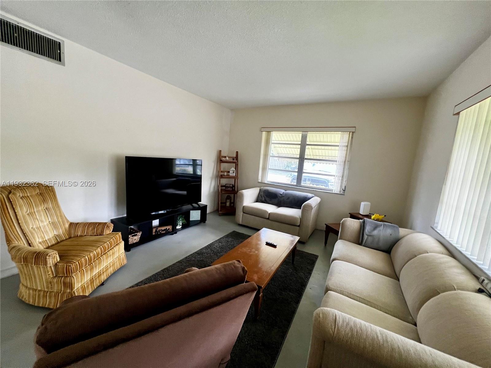 A living room features a television, a coffee table, and various seating options — 1501 Arthur St # 5, Hollywood FL 33020, HOLLYWOOD, FL