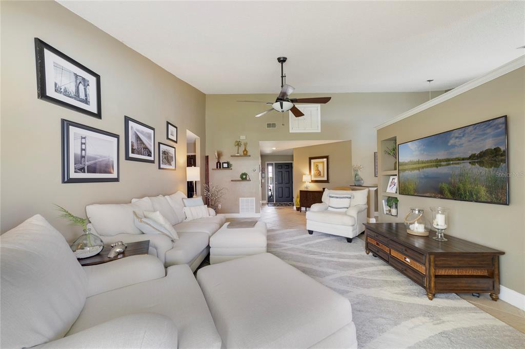 A living room features a white sectional sofa, a television, and a ceiling fan — 504 WEXDON COURT, LAKE MARY, FL