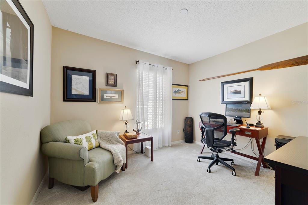 A home office features a green armchair, a wooden desk, and nautical-themed wall decor — 504 WEXDON COURT, LAKE MARY, FL