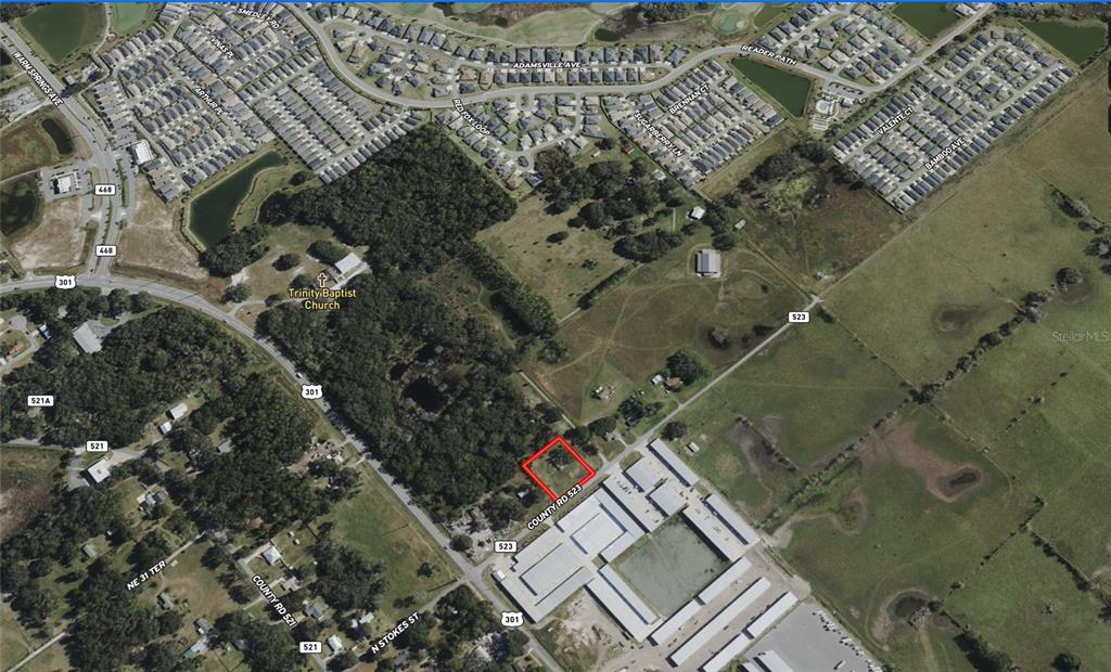 An aerial map view highlights a rectangular property lot outlined in red along a road — 2889 COUNTY ROAD 523, WILDWOOD, FL
