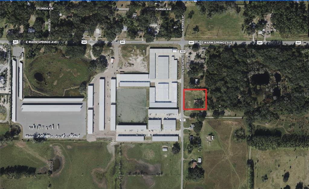 An aerial map view shows a rectangular property outlined in red next to a storage facility — 2889 COUNTY ROAD 523, WILDWOOD, FL