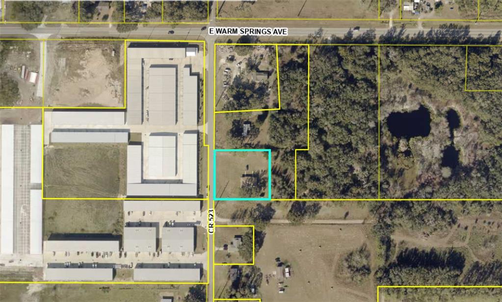 This aerial map shows a residential property highlighted in blue among surrounding lots and buildings — 2889 COUNTY ROAD 523, WILDWOOD, FL
