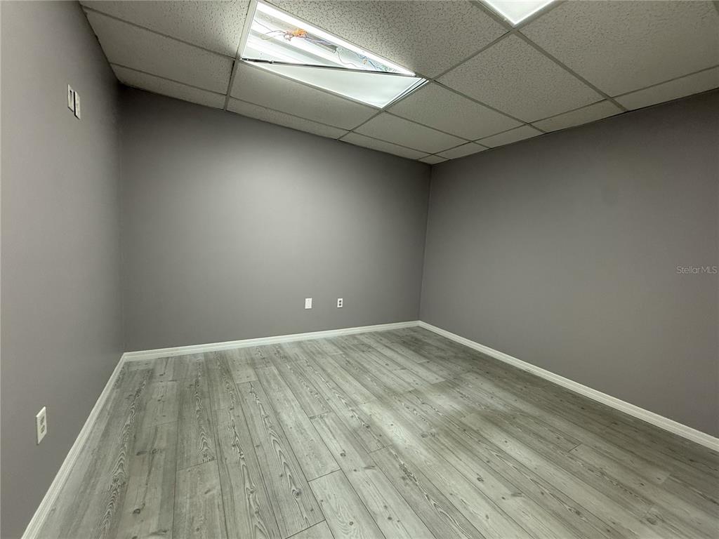 An empty office with gray walls, wood-look flooring, and a drop ceiling — 2007 W KENNEDY BOULEVARD UNIT A, TAMPA, FL