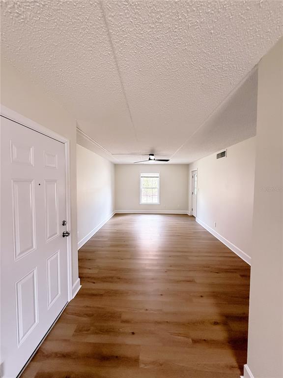 An empty room with light wood-look flooring, white walls, and a ceiling fan — 1275 85TH AVENUE UNIT 1275B, ST PETERSBURG, FL
