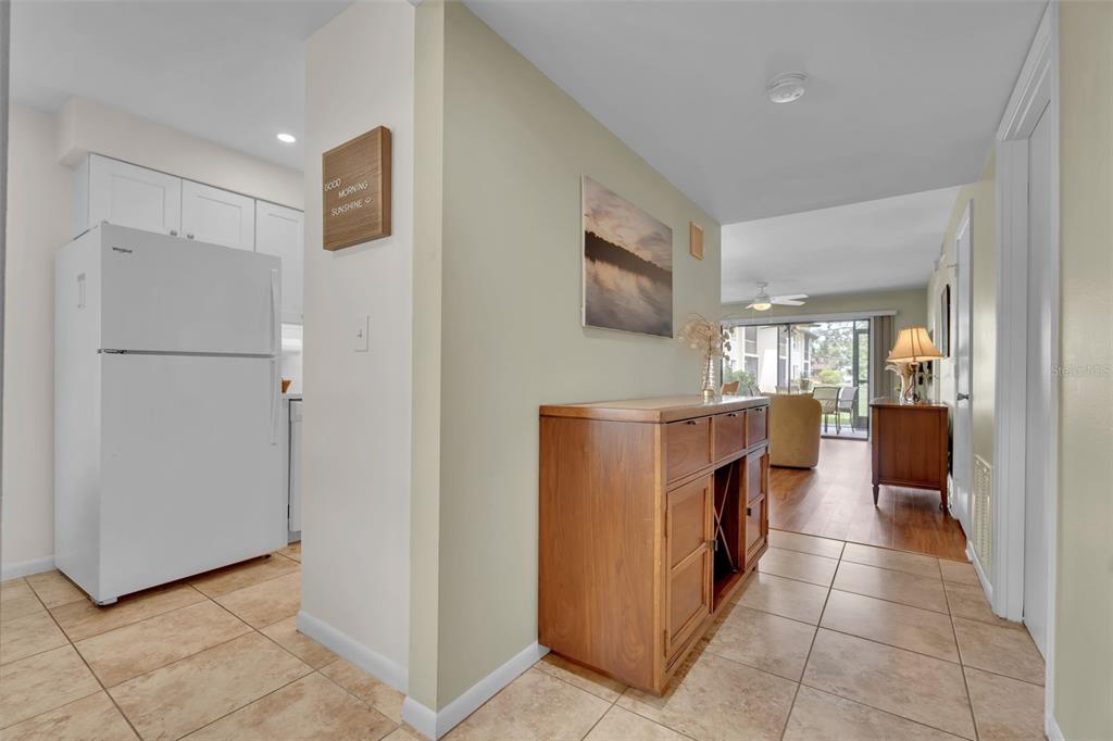 A view from a tiled entryway looking toward a living area with wood flooring — 4644 LONGWATER UNIT 97, SARASOTA, FL