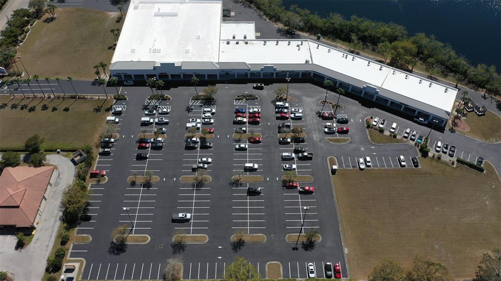 An aerial view shows a commercial strip mall building with a large parking lot — 1125,1127,1131 BAL HARBOR BOULEVARD UNIT 1125, PUNTA GORDA, FL