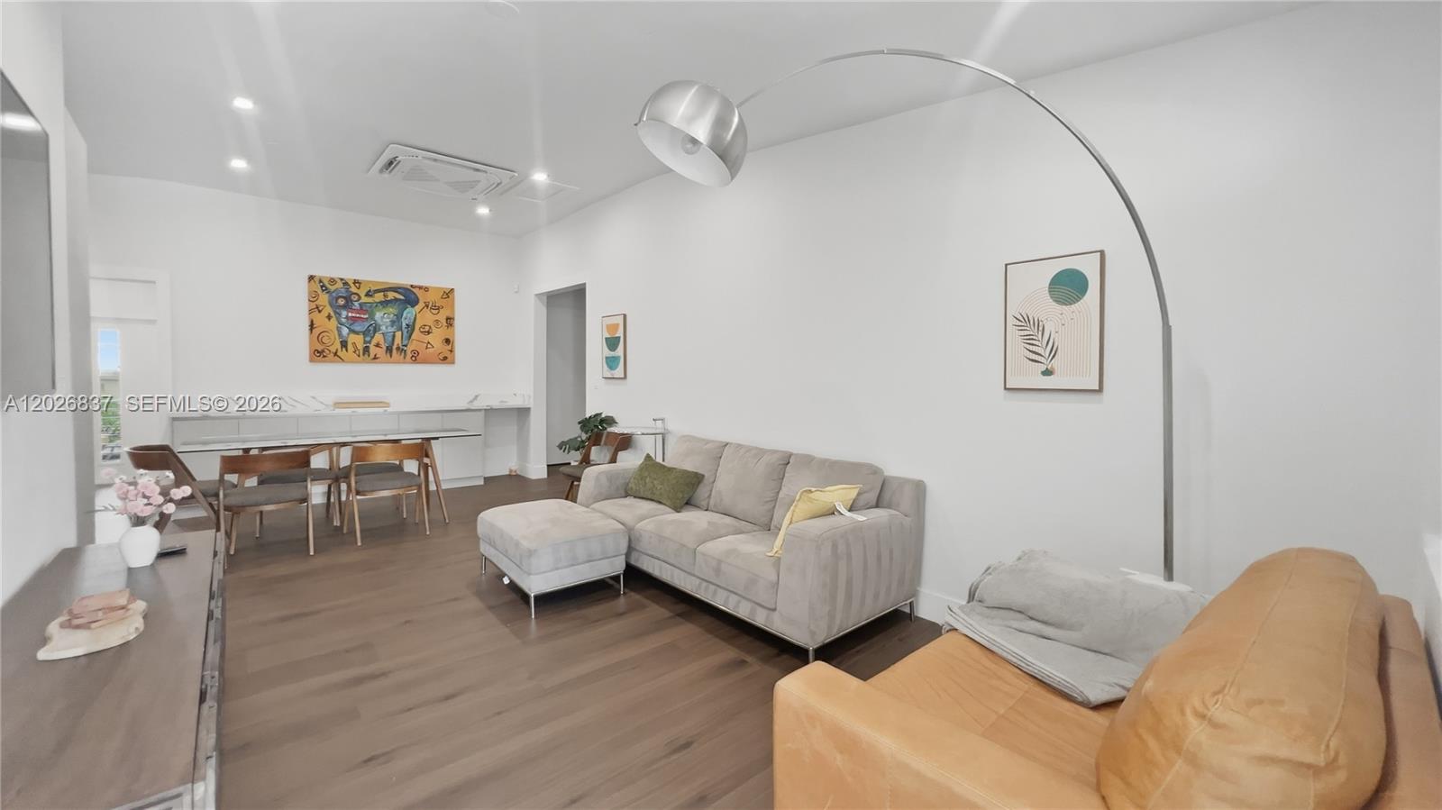 A living room features a grey sectional sofa, a tan armchair, and a dining area — MIAMI, FL