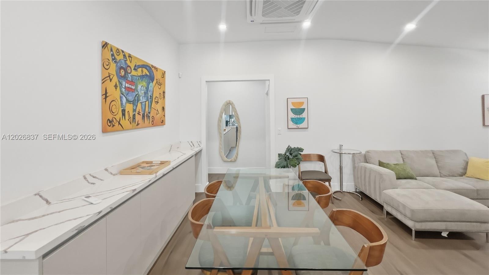 A dining area features a glass table, wooden chairs, and a long marble-topped sideboard — MIAMI, FL