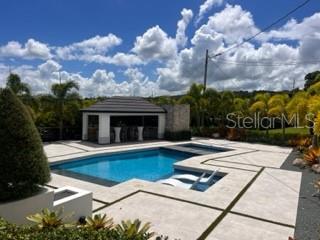 A swimming pool with a sun shelf sits in front of a covered outdoor pavilion — Lot 8 PR-159 Km 1.9 Inter BO. UNIBON, MOROVIS, PR