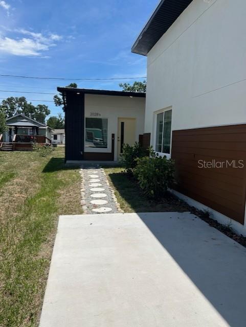 A concrete patio leads to a modern house entrance with a stone walkway — 2020 14TH AVENUE S UNIT 2020 1/2, ST PETERSBURG, FL