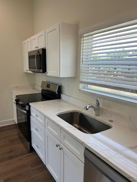 A kitchen features white cabinets, a stainless steel microwave, a range, and a marble-patterned countertop — 2020 14TH AVENUE S UNIT 2020 1/2, ST PETERSBURG, FL