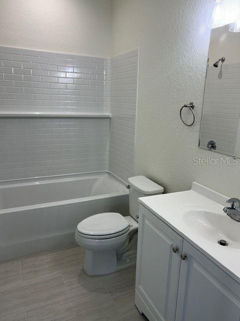 A bathroom features a white vanity, a toilet, and a bathtub with white subway tile — 2020 14TH AVENUE S UNIT 2020 1/2, ST PETERSBURG, FL