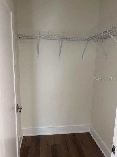 A small walk-in closet features white walls, dark wood flooring, and wire shelving — 2020 14TH AVENUE S UNIT 2020 1/2, ST PETERSBURG, FL