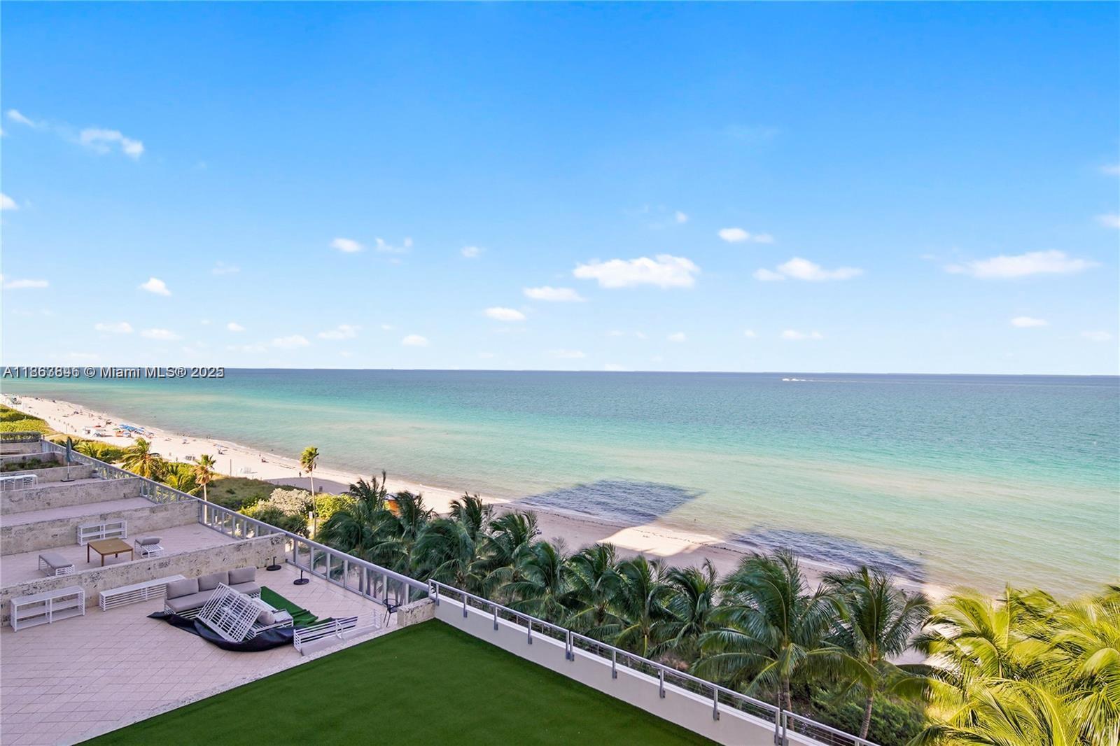 An elevated view of a beachside terrace with outdoor furniture and palm trees — 6899 Collins Ave # 808, Miami Beach FL 33141, MIAMI BEACH, FL